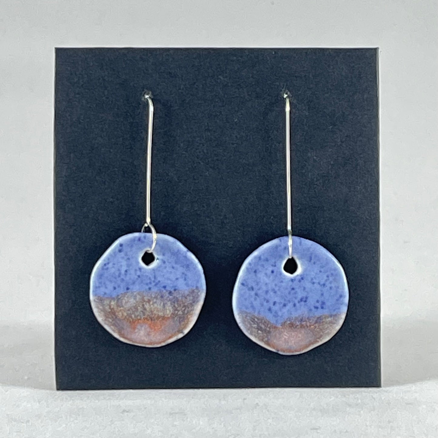 A pair of hand formed porcelain earrings in blue with mauve and orange flecks