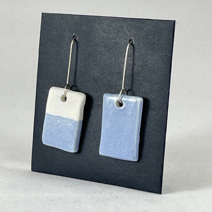 A pair of hand formed porcelain earrings in delicate blue and white. Side view showing thin earring profile