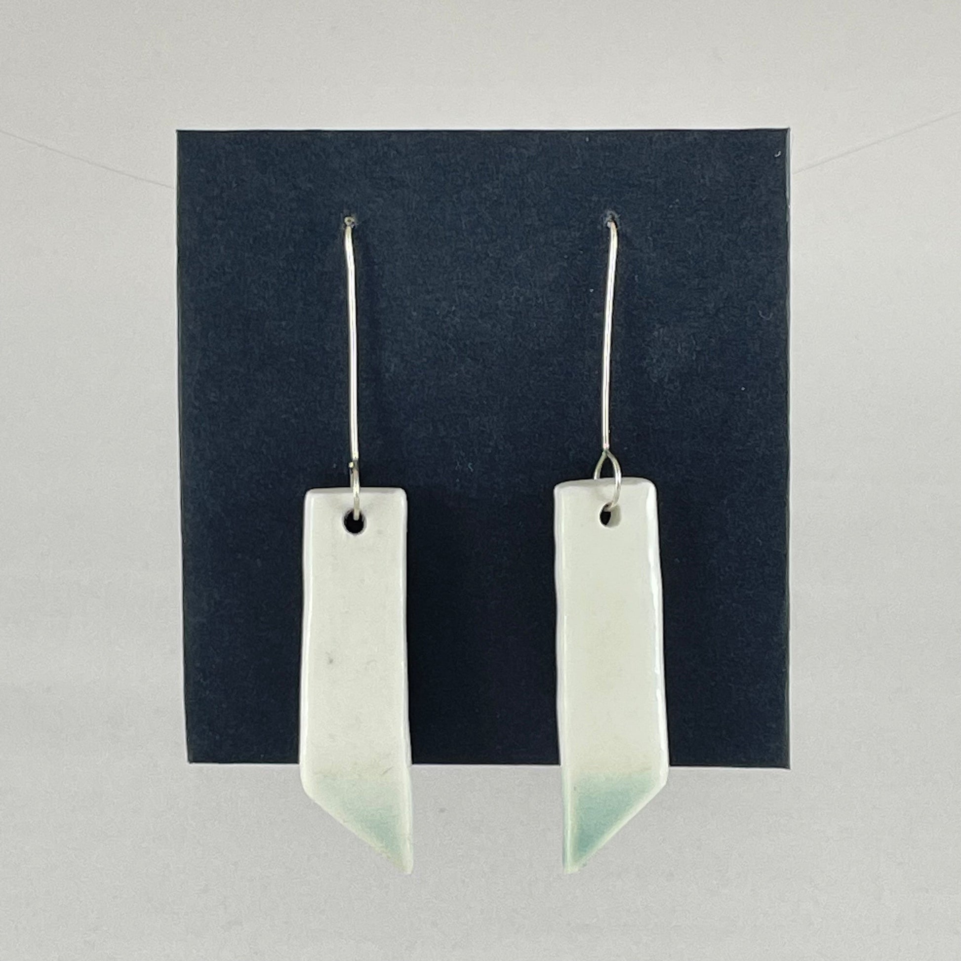 A pair of hand formed porcelain pendant earrings in glossy white and a hint of mint green
