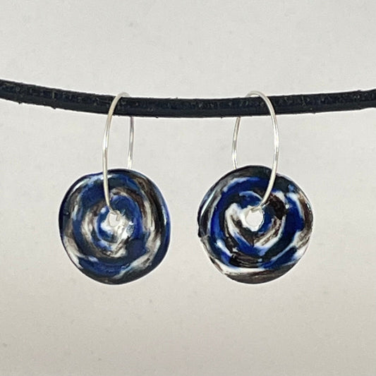 A pair of silver hoops with hand formed porcelain pendants in blue black and white