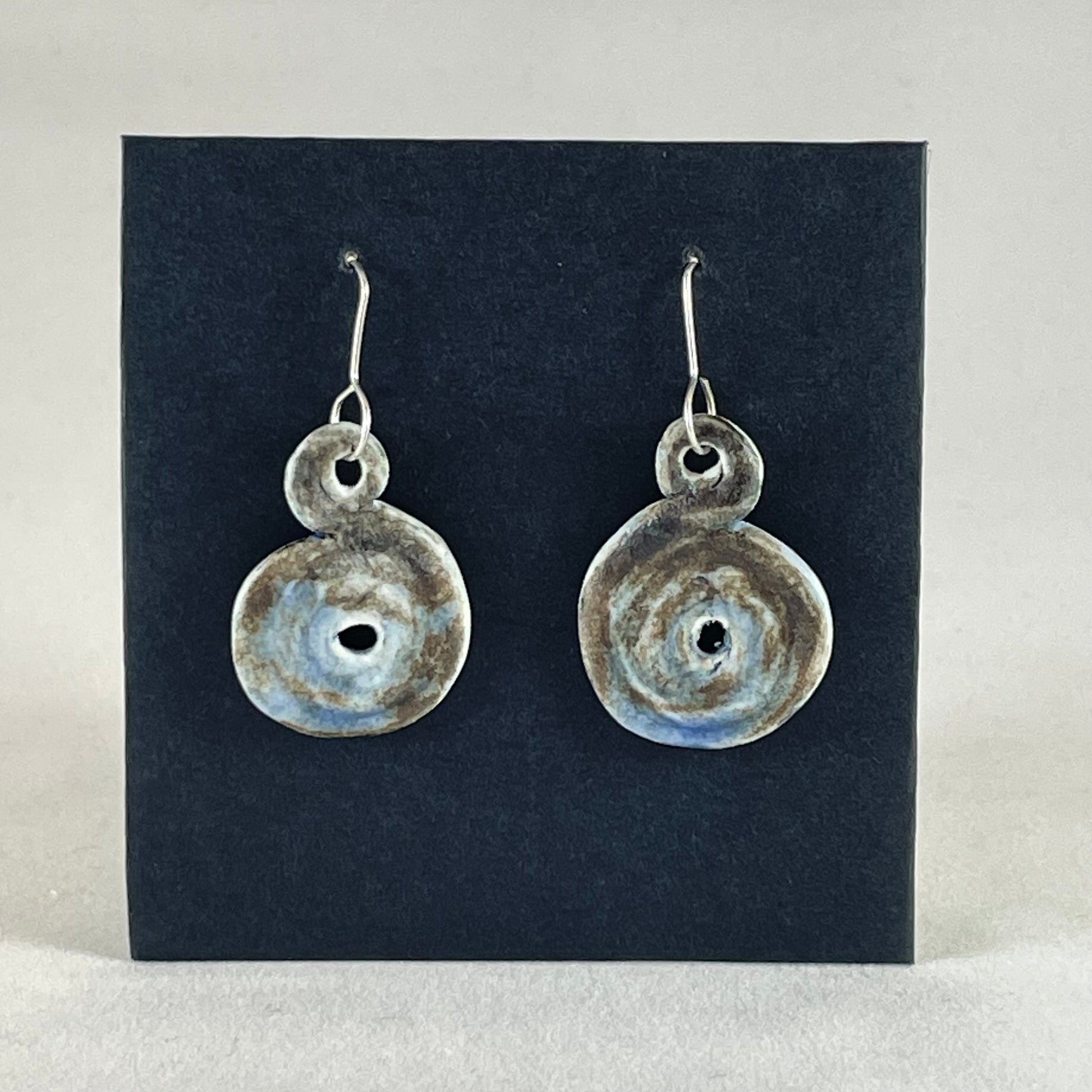 Pair of hand coiled pendant earrings. Blue brown and white textured pattern.