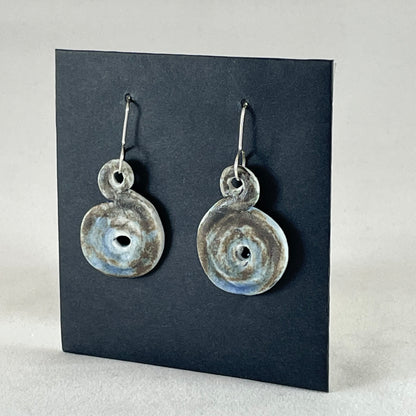 Pair of hand coiled pendant earrings. Blue brown and white textured pattern. Side view