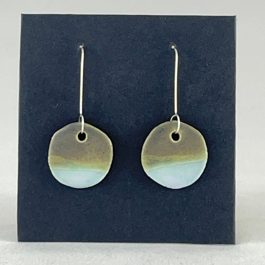 A pair of circular porcelain earrings in blue and green. On sterling silver earrings hooks.
