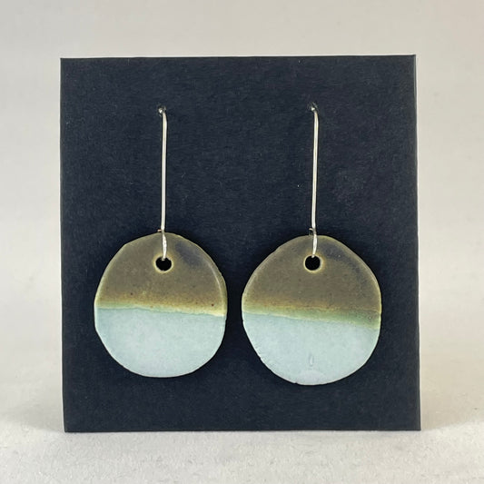 A pair of circular porcelain earrings in blue and green. On sterling silver earrings hooks.