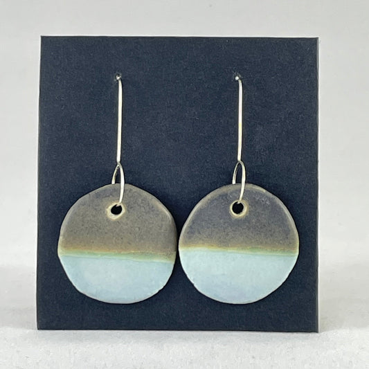 A pair of circular porcelain earrings in blue and green. On sterling silver earrings hooks.