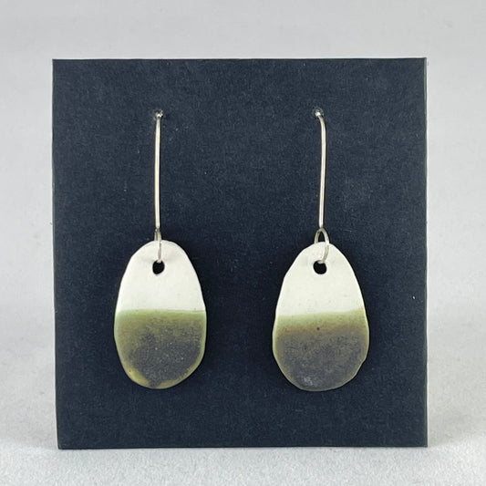 A pair of oval shaped porcelain earrings in white and green. On sterling silver earrings hooks.