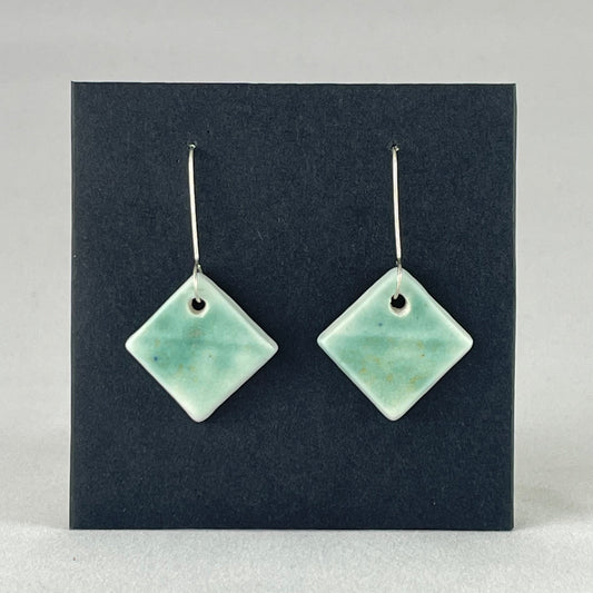 A pair of diamond shaped porcelain earrings in green. On sterling silver earrings hooks.
