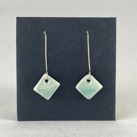 A pair of diamond shaped porcelain earrings in green. On sterling silver earrings hooks.