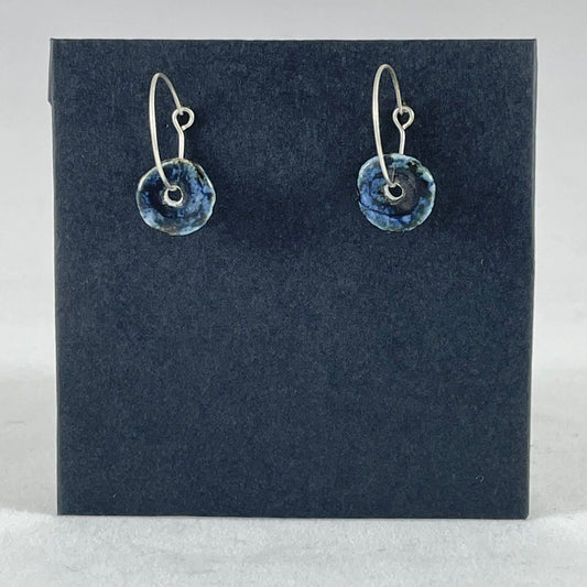 A pair of blue hand coiled porcelain earrings on sterling silver hoops. Photographed on a graphite coloured background