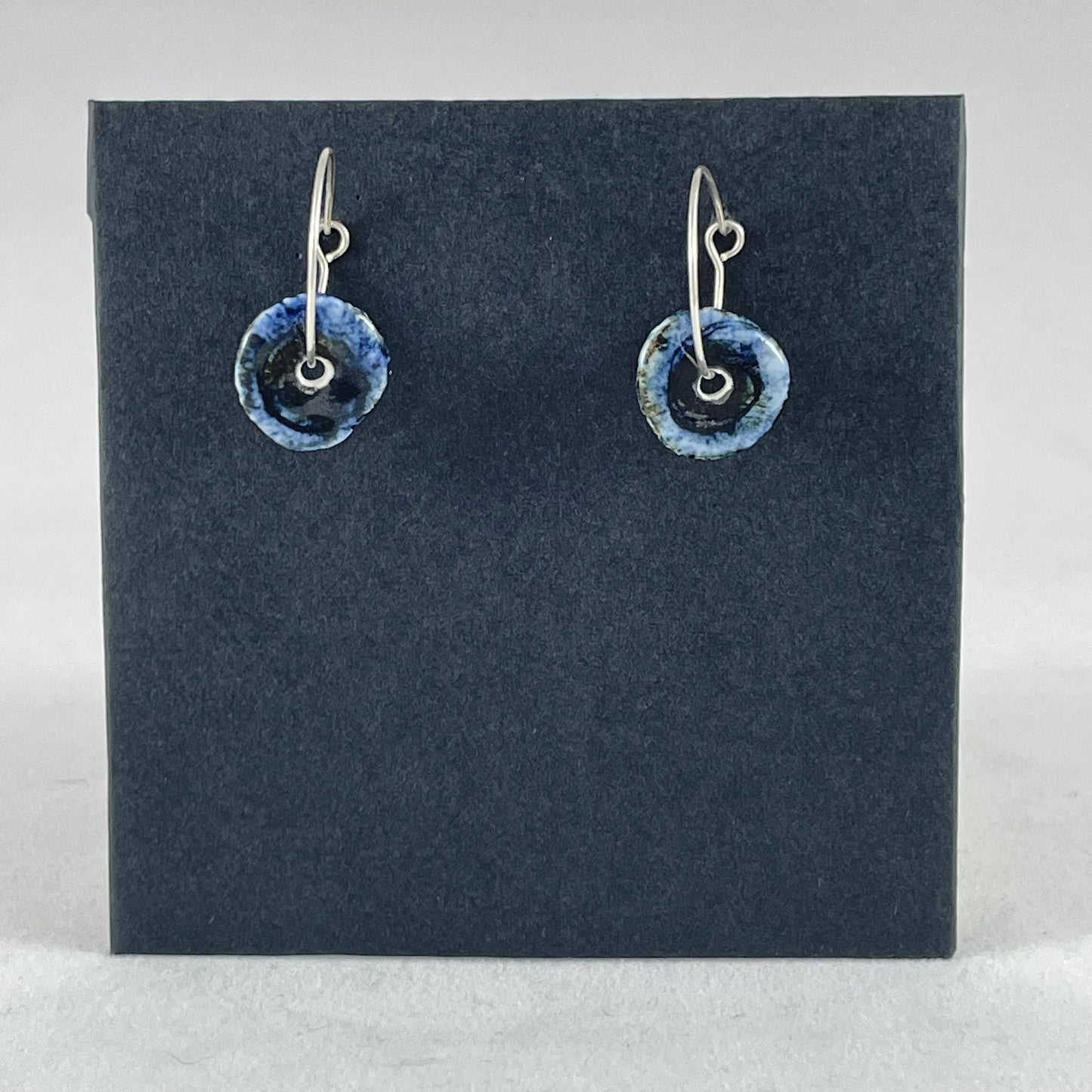 A pair of blue hand coiled porcelain earrings on sterling silver hoops.