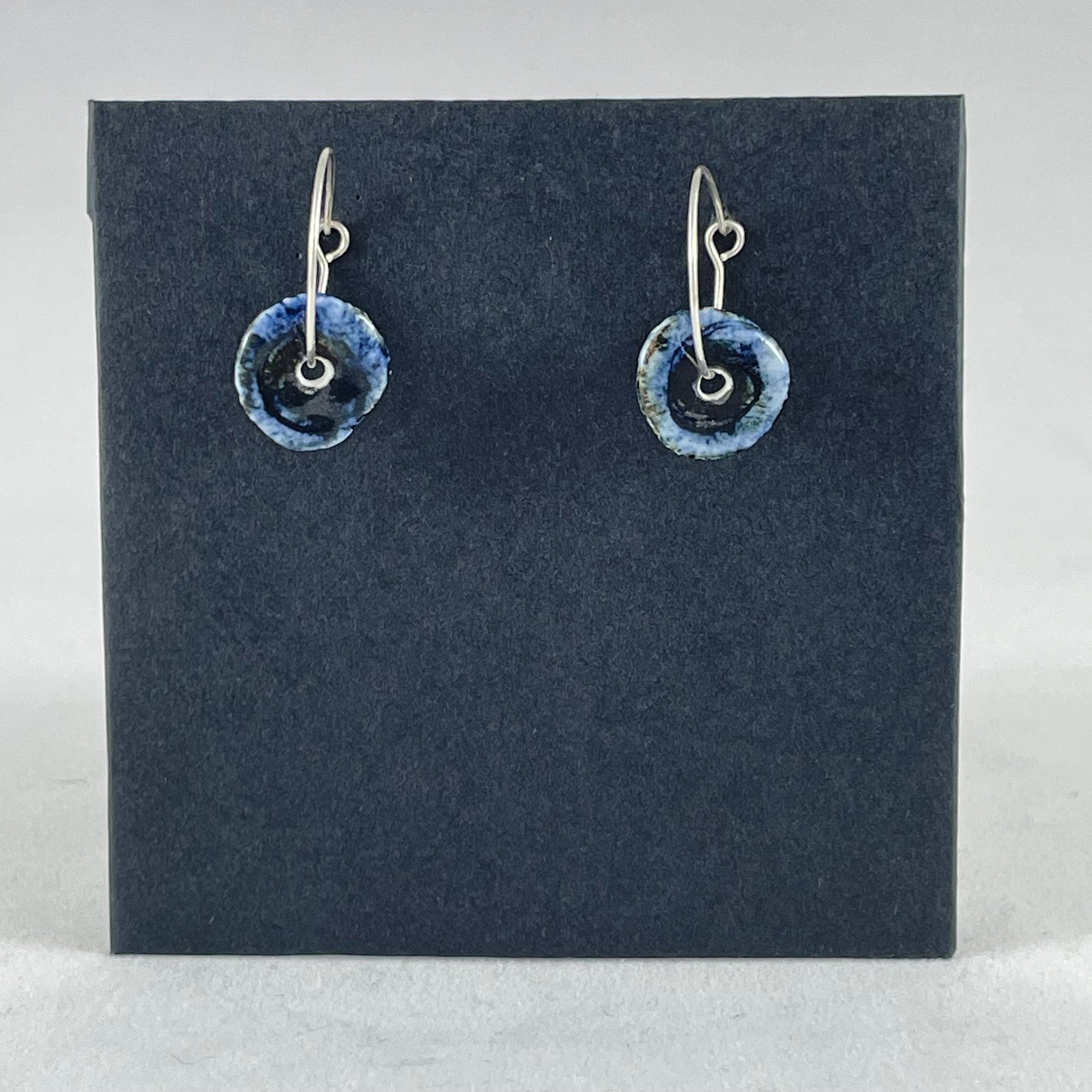 A pair of blue hand coiled porcelain earrings on sterling silver hoops.