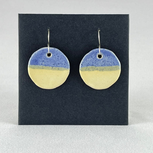 A pair of circular porcelain earrings in yellow and blue. On sterling silver earrings hooks. 