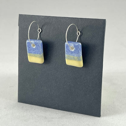 A pair of porcelain earrings in yellow and blue. Cute rectangular pendants on sterling silver hooks. Side view