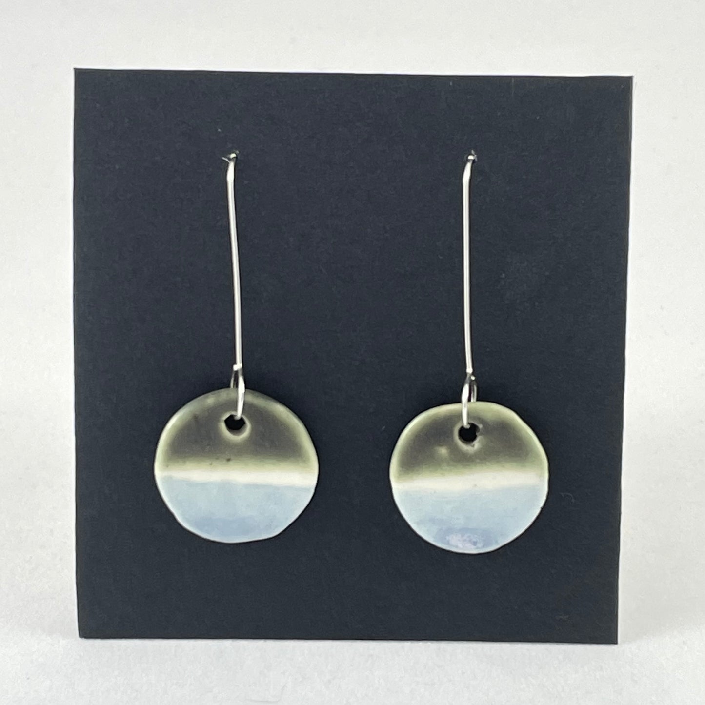 Pair of circular porcelain earrings with  bands of colour: dark green, white and pale blue. On long sterling silver earring hooks.