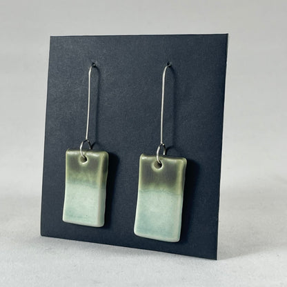 A pair of rectangular shaped porcelain earrings in mint and green. On sterling silver earrings hooks. Side view