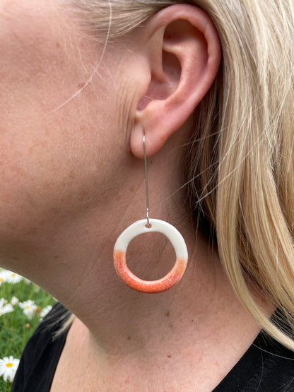 Pair of porcelain hoop earrings in white and orange. 