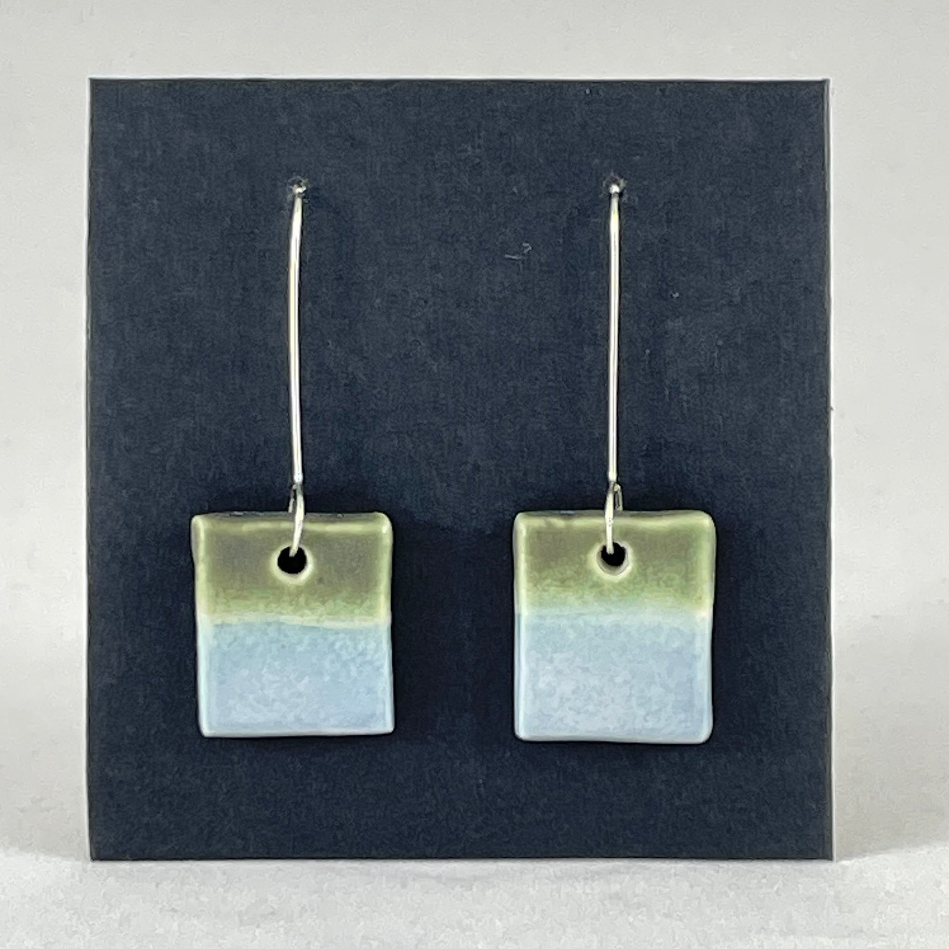 A pair of square shaped porcelain earrings in blue and green. On sterling silver earrings hooks.